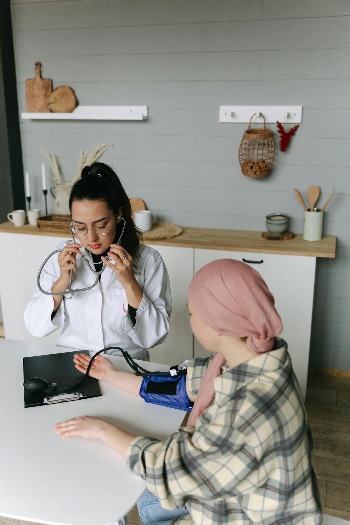A doctor checks a patient's blood pressure in a medical setting with caring attention.